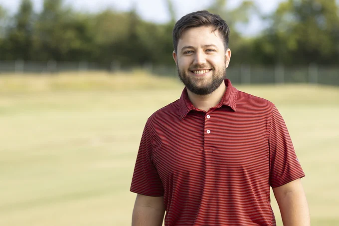 Wendell Hutchens poses for a photo with turfgrass in the background