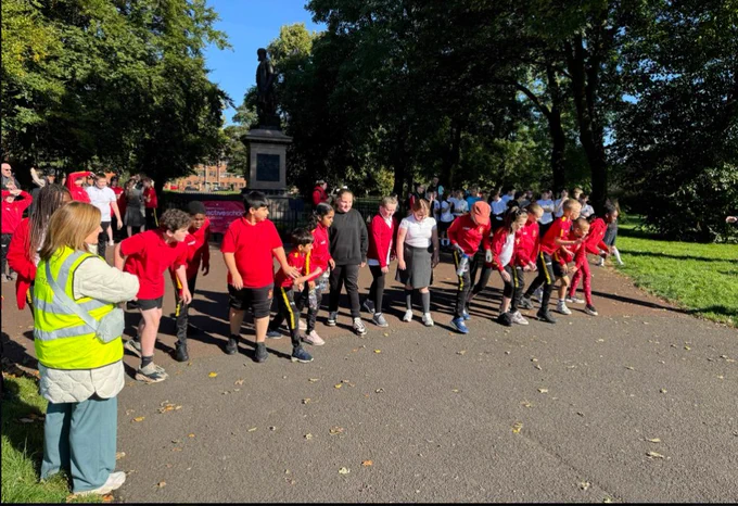 Kids on the start line with red jumps on. 