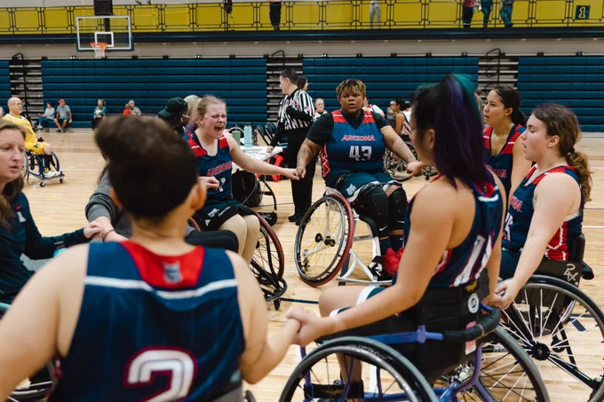 A wheelchair basketball team in a group huddle 