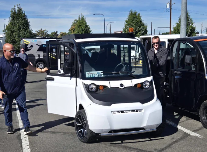 State employees looking at a low-speed electric vehicle.