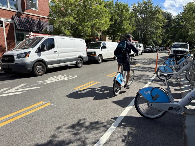 A person riding a Divvy bike on the Berwyn greenway, using the contraflow lane 