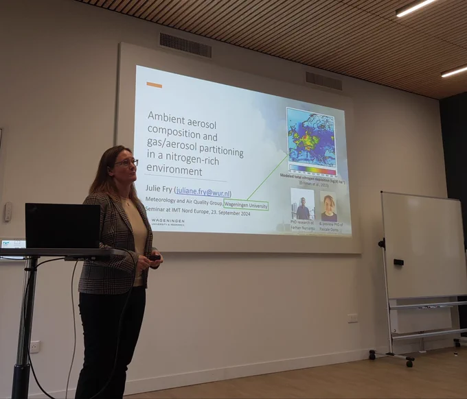 Juliane Fry in front of her title slide: "Ambient aerosol composition and gas/aerosol partitioning in a nitrogen-rich environment"