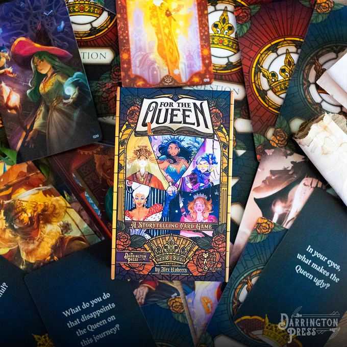 For the Queen, Darrington Press's card based storytelling game. Picture of the game sitting on top of a spread of the cards in the game. 