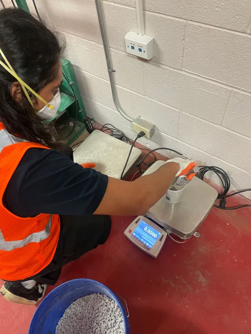 A student mixes and weighs a concrete sample in a cup