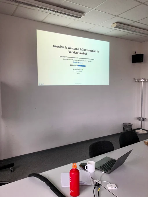 A photo of slides with the title "Session 1: Welcome & Introduction to Version Control"
