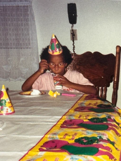 Black kid celebrating a Barney birthday.