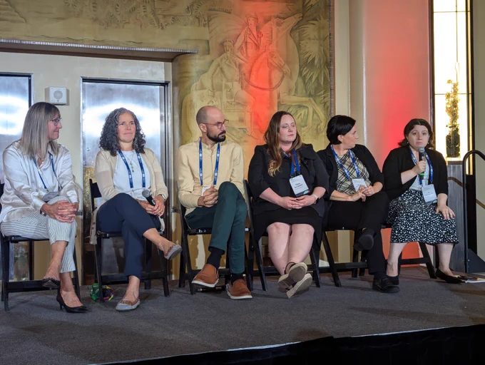 Panelists on stage at the session on social prescription for caregivers. CCCE's executive director Liv Mendelsohn holds onto a microphone while speaking. 