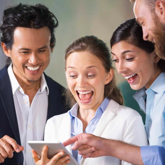 surprised people looking at an electronic device