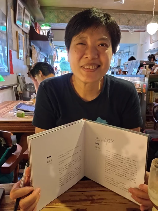 Taiwanese picture book illustrator Joyce Sun holds open one of her books