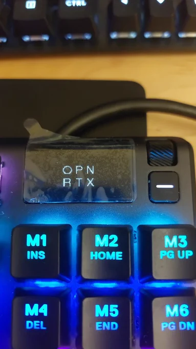 Picture of a keyboard with an OLED display showing the OpenRTX logo.