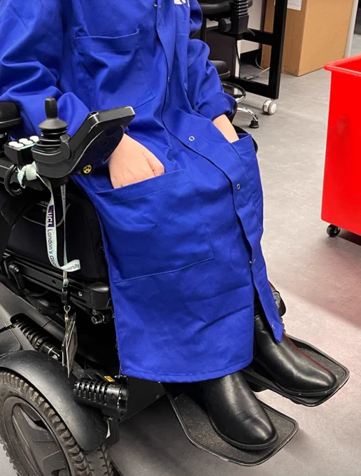 A close up of the coat over Anna’s legs, with her hands reaching in the pockets that fall just below her knees.