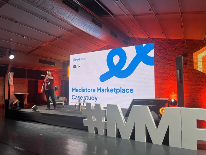 speaker at stage with slide in the background about Medistore marketplace case study