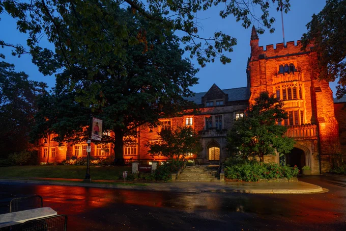 McMaster’s University Hall lit up in orange lights. 