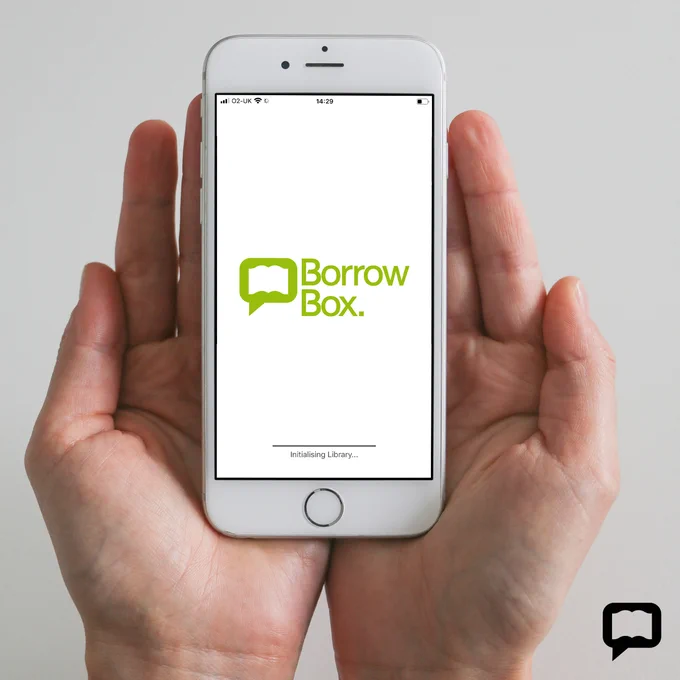 A pair of hands holding a smartphone displaying the borrowbox logo.