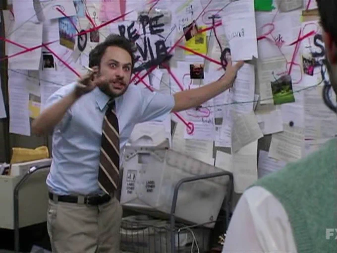 Meme of maniac man standing before a murder board of linking papers solving a mystery with a crazed look in his eye as if he hasn't slept in days and a smokes in hand