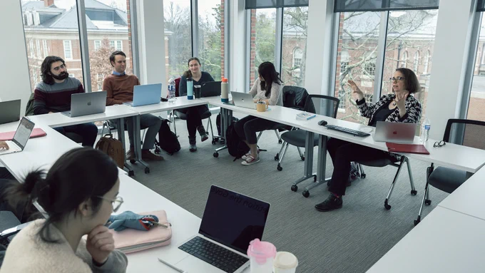 Tori Ekstrand (top right) teaches media law in Curtis Media Center to a group of students sitting around a table. 