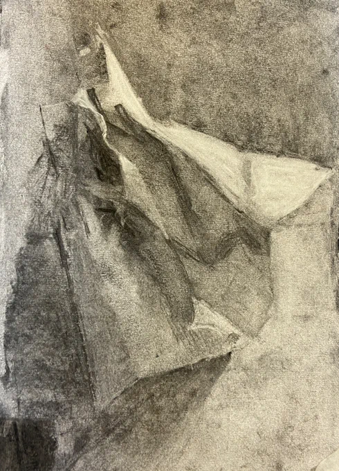 Charcoal drawing of folded paper.