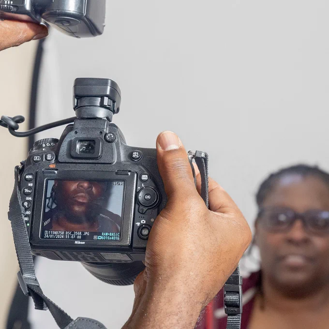 A black woman being photographed by Karel.