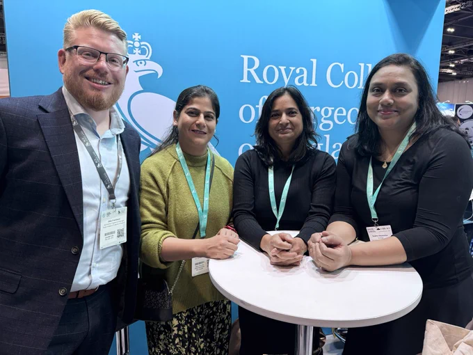 A group of people smile for a photo at the RCS England stand at Future Surgery.