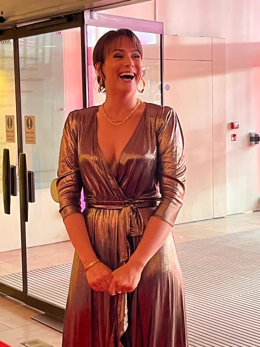 a. woman smiling in a shimmering dress