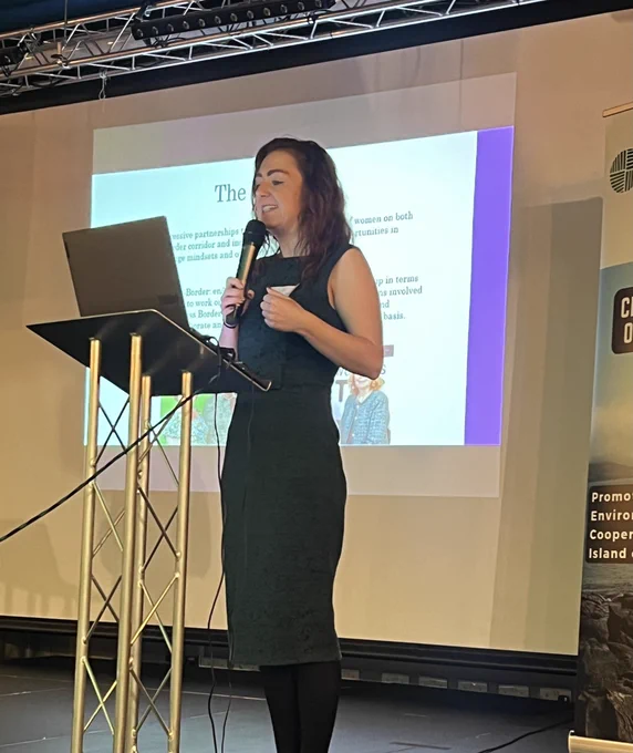Photograph of Tracey speaking to the delegates.