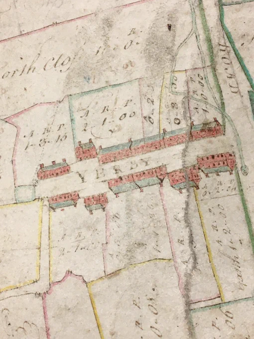 Cropped close -up of historic map showing houses in red