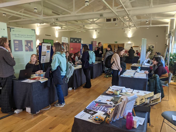 Photograph of attendees and stalls at the 2024 Fair in Elena Hall, Jesus College, Cambridge.
