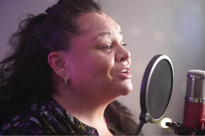 Keala Settle sings into a microphone