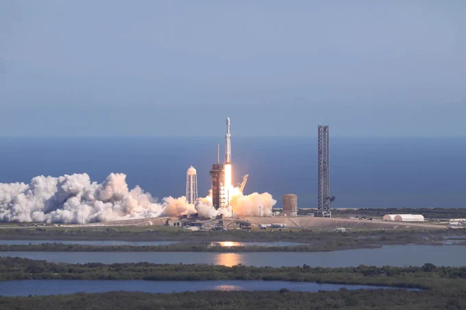 A SpaceX Falcon Heavy rocket, carrying NASA’s Europa Clipper spacecraft, lifts off from Launch Complex 39A at NASA’s Kennedy Space Center in Florida at 12:06 p.m. EDT (1606 UTC) on Monday, Oct. 14, 2024. A blue sky is met by the horizon of the ocean off the coast of Florida. Credit: NASA/Kim Shiflett