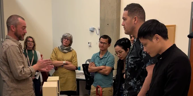 A group of people engaging in a discussion around a table displaying various maps and documents.