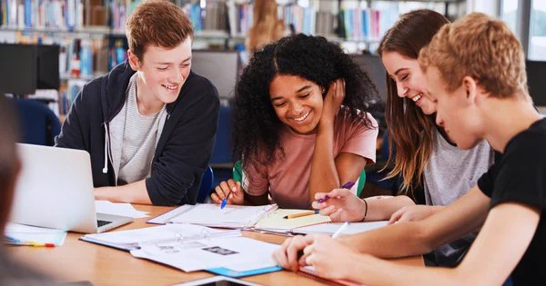 4 students studying together in a library 