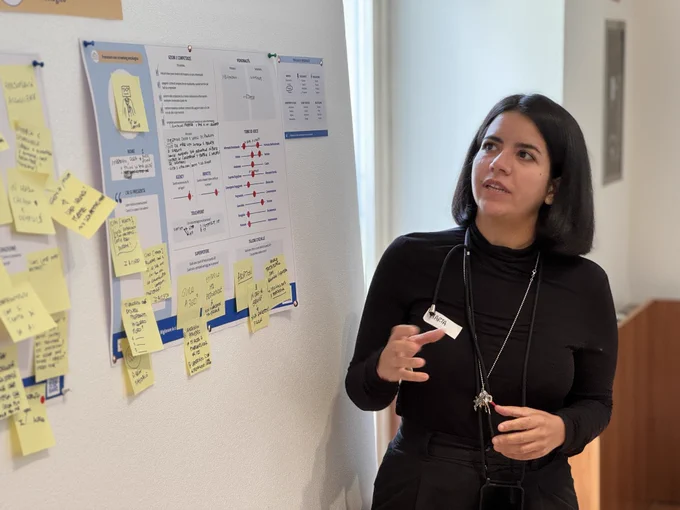 Una partecipante al workshop presenta un poster del profilo di un agente conversazionale