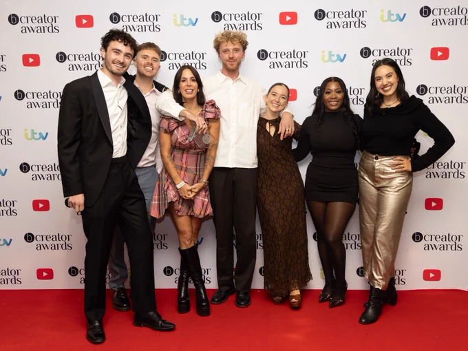 An image of Sixteenth employees posing in front of the bCreator step and repeat.