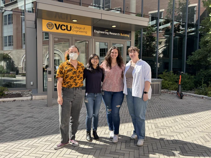 Four biomedical engineering students standing in front of the Engineering Research Building at the College of Engineering.