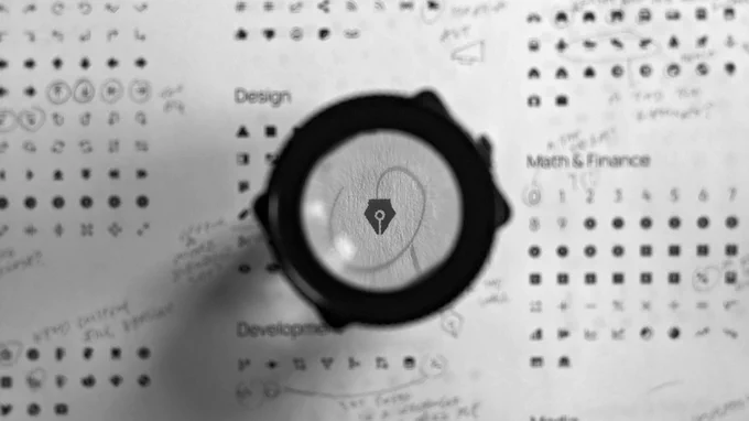 An icon of a fountain pen nib magnified under a loupe