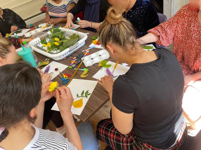 women creating artwork with leaves and items from nature in a Talitha Arts therapeutic arts workshop