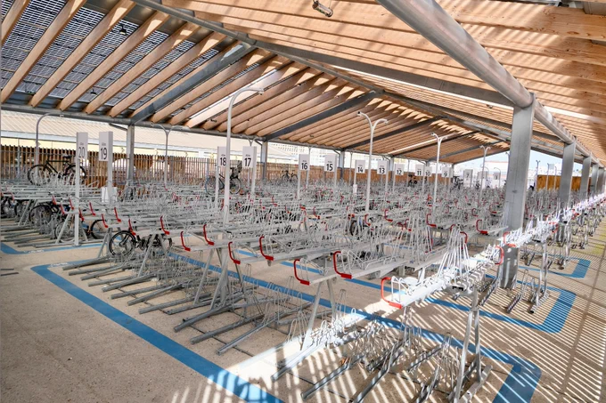 An elegant new 1,200-bike parking facility at Gare du Nord Station in Paris includes integrated signage, a guarded entrance, two-tiered racks, and a repair station.