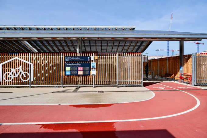 An elegant new 1,200-bike parking facility at Gare du Nord Station in Paris includes integrated signage, a guarded entrance, two-tiered racks, and a repair station.