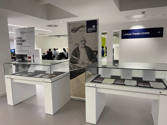Two glass display cases on level 3 of the Andersonian Library featuring photographs and documents from the Univeristy of Strathclyde's first Asian and Black Honorary Graduates.