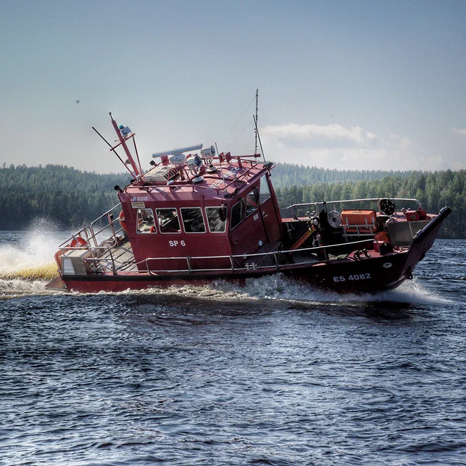 Pelastuslaitoksen vene kaartaa vedessä.