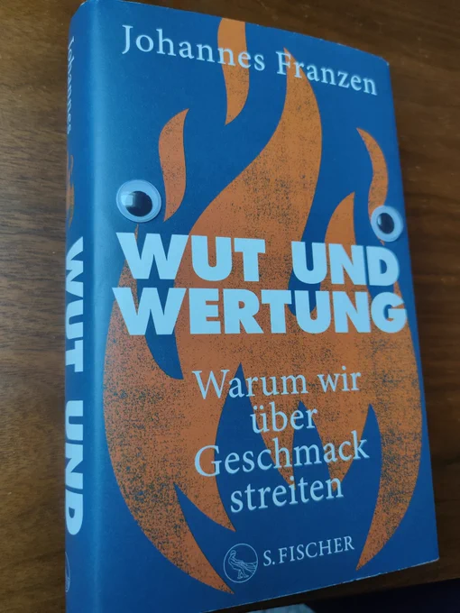 Ein Foto von Johannes Franzens Buch "Wut und Wertung". Darauf wurden Bastelaugen gelegt
