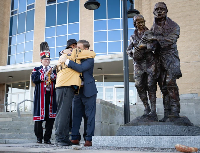 Premier Furey, Saqamaw Mi’sel Joe and Chief Brendan Mitchell near bronze statue outside the Confederation Building.