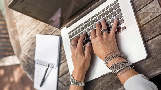 Photo of a person's hands working on a laptop at a wooden table
(Photo by LinkedIn Sales Solutions on Unsplash_Writing-Laptop)