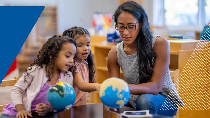 A teacher and her students looking at a globe.