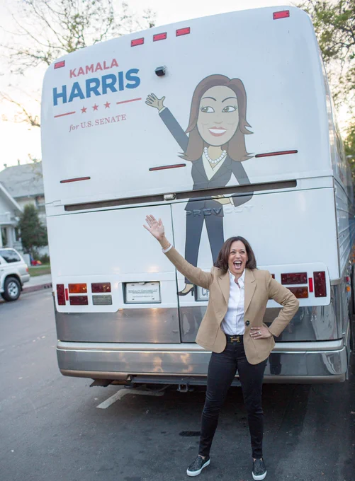 Senate candidate Kamala Harris poses in front of her former campaign bus. The pose she holds is the same as a drawing on the outside of the bus. 