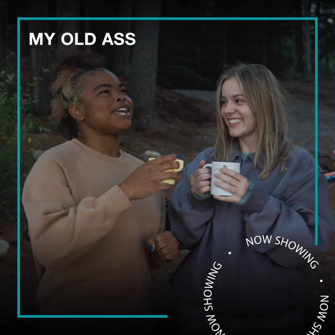 Two teenage girls stand outside in a forest holding mugs. Text - My Old Ass, Now Showing