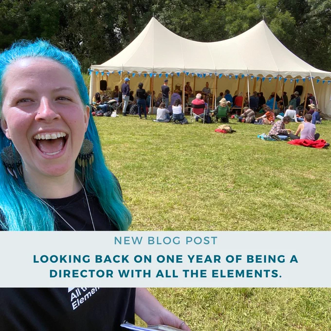 Frankie a white woman with blue hair smiles in front of a busy festival marquee text at the bottom of the screen reads new blog post, looking back on one year of being a director with all the elements. 