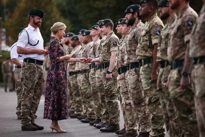 The Duchess of Edinburgh hands a medal to a soldier in uniform.
