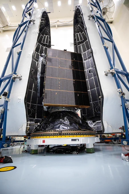 The Europa Clipper spacecraft stands between the two large SpaceX Falcon fairing halves inside the Payload Hazardous Servicing Facility at Kennedy Space Center.