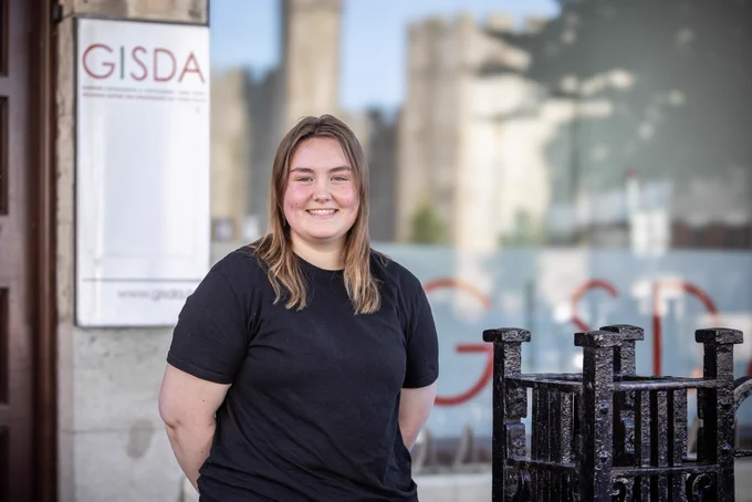 Woman standing in front of GISDA / Menyw yn sefyll o flaen GISDA